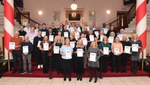 A group of people holding certificates